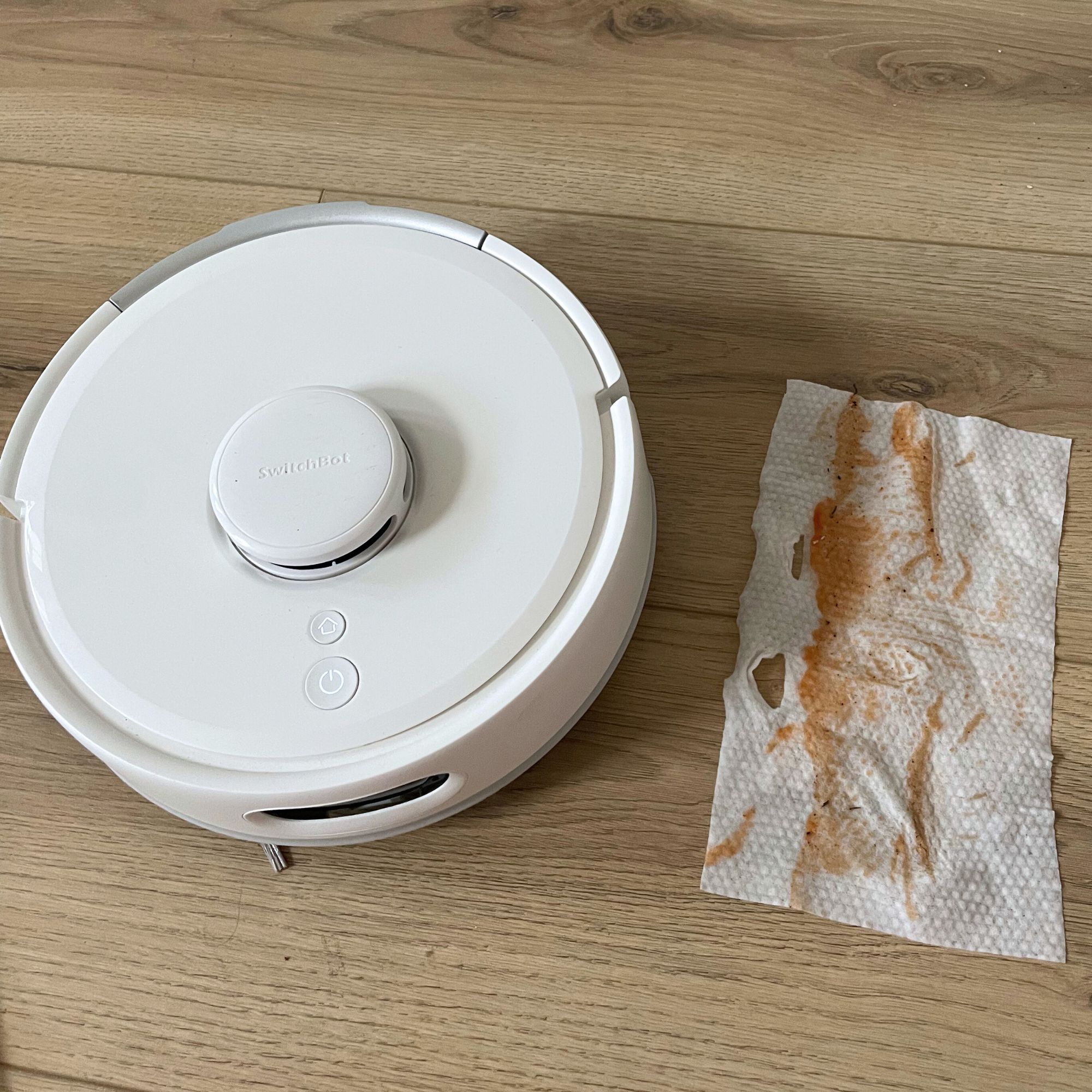SwitchBot K11+ Robot Vacuum Cleaner with Mop with a dirty mop wipe next to it