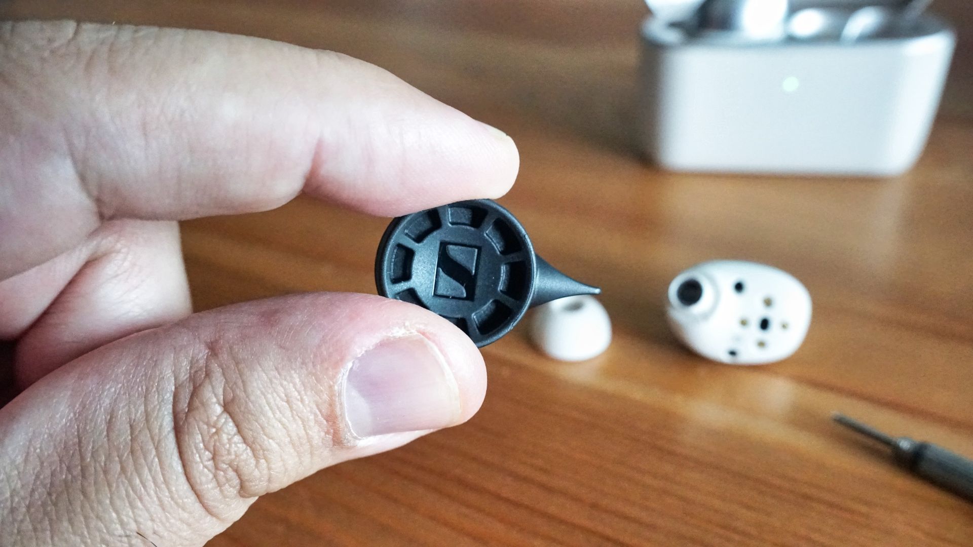 Sennheiser Momentum True Wireless 5 in white, showing details of the buds held in a hand