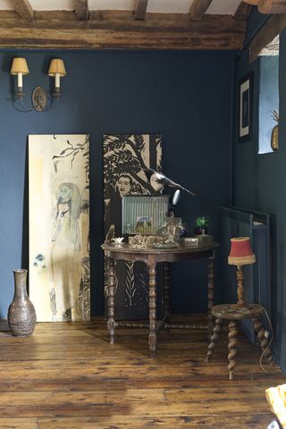 dark interior with wooden beams and floor with artwork and feature table