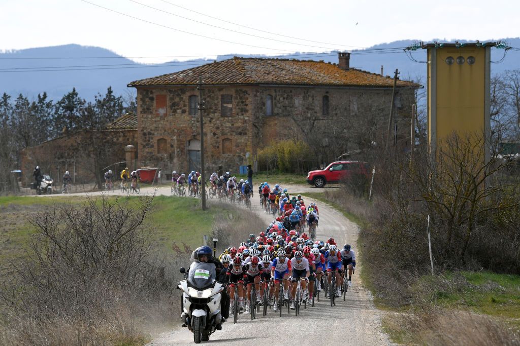 SIENA ITALY MARCH 05 The peloton passing through a gravel strokes sector during the Eroica 16th Strade Bianche 2022 Mens Elite a 184km one day race from Siena to Siena Piazza del Campo 321m StradeBianche WorldTour on March 05 2022 in Siena Italy Photo by Tim de WaeleGetty Images