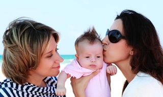 lesbian parents kissing baby