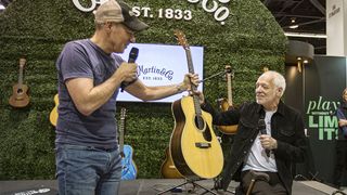 ANAHEIM, CALIFORNIA - JANUARY 22: C.F. Martin & Co. President and CEO Thomas Ripsam (L) gifts musician Peter Frampton at Martin guitar at the C.F. Martin & Co. booth during Global Media Day at The NAMM Show 2025 at Anaheim Convention Center on January 22, 2025 in Anaheim, California. (Photo by Daniel Knighton/Getty Images)