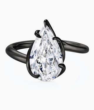 Thelma West Ring is a black ring with a pear-cut diamond hugged by black trim.