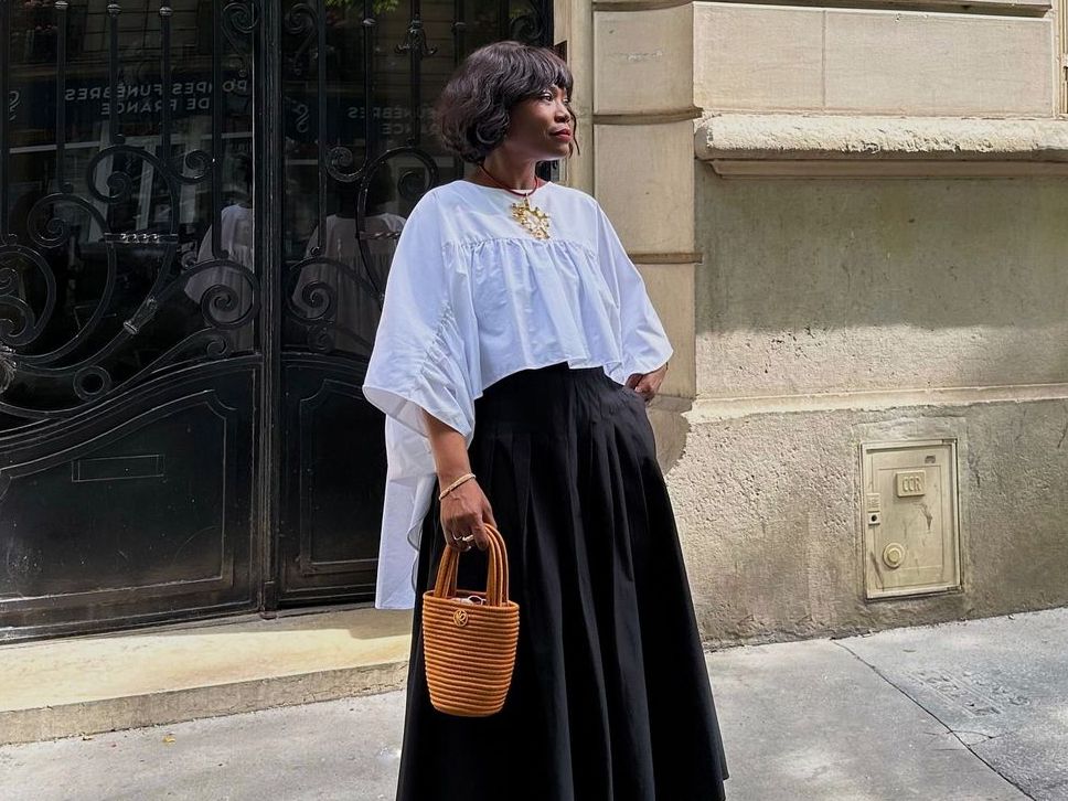 French fashion Instagram influencer Frannfyne in black high-waisted skirt and white shirt in Paris.