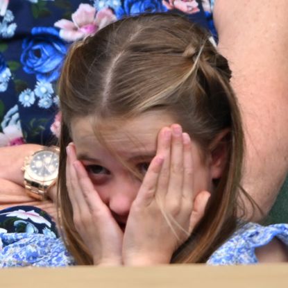 Princess Charlotte with her head in her hands at Wimbledon