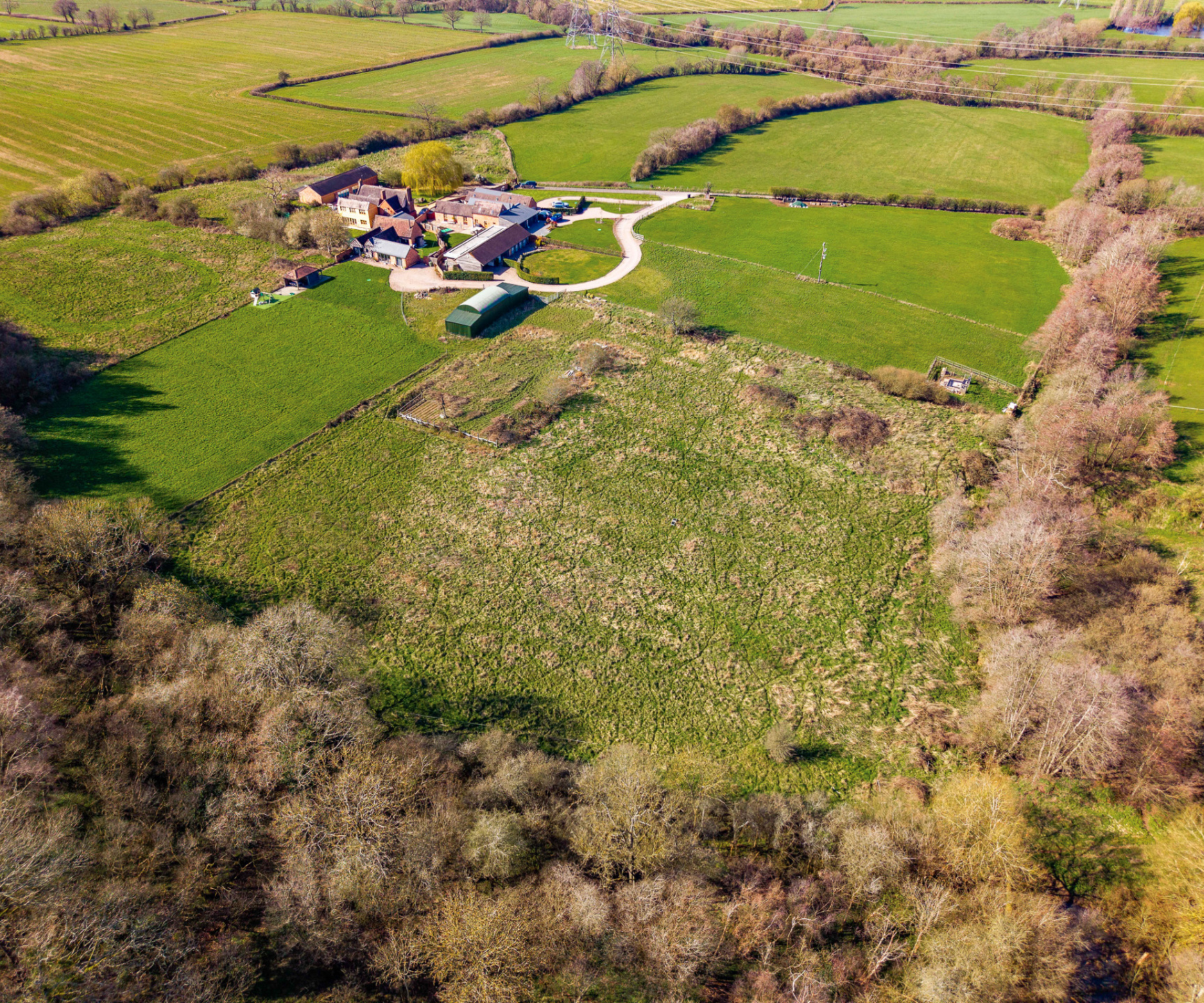 Plot of land with houses and dutch barn in left corner