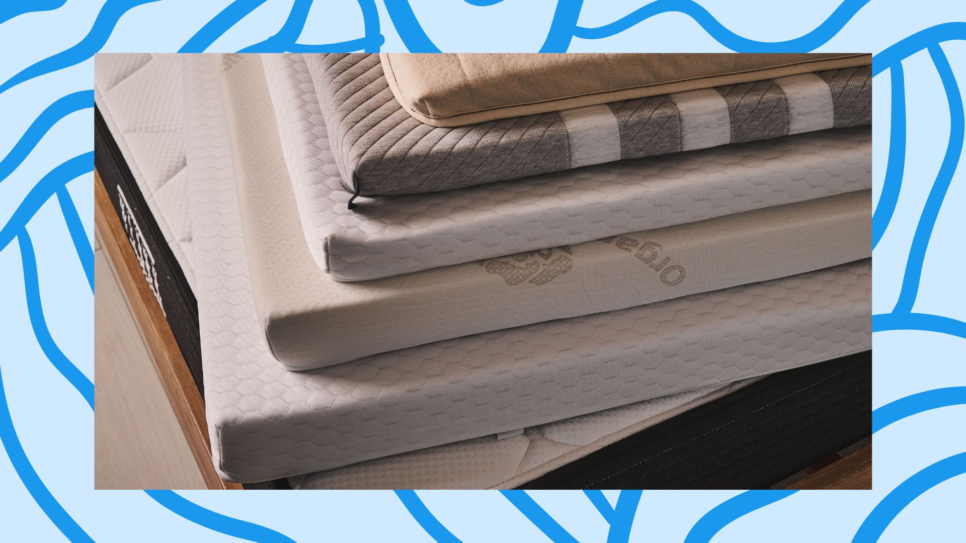 A photograph of a stack of mattress toppers pasted onto a paste-blue background with a cobalt-blue pattern.