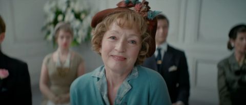 Lesley Manville smiles with delight at a fashion show in Mrs. Harris Goes To Paris.