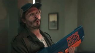 Michael Cera breaths deep while pumping a water gun against the wall in The Running Man.