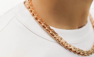 Woman wearing gold bicycle chain necklace by Nadine Ghosn