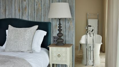 Primary bedroom with green velvet headboard and ensuite