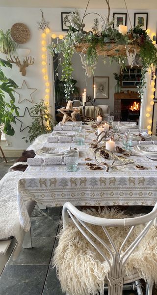 Christmas table with foliage arrangement, sheepskin seating and white decor