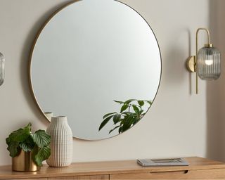 Briz Wall Lamp on the wall beside rounded mirror