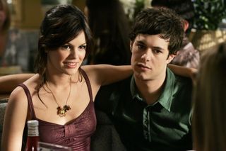 Kaitlin Cooper and seth cohen sit in a booth with their arms around each other in a still From 'The O.C.'