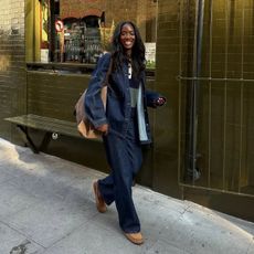 An image of @_livmadeline wearing an all navy outfit, including a denim jacket, denim jeans and suede shoes, while out in London.