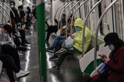 People wearing facemasks travel in the subway in Wuhan
