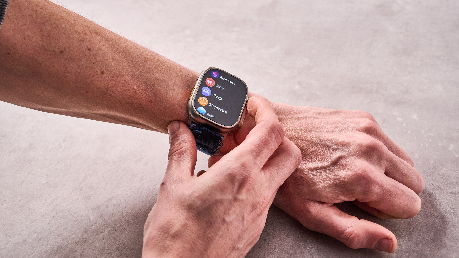 The Apple Watch Ultra 2 on a man's wrist, as he selects the sleep tracking menu item using the Digital Crown.