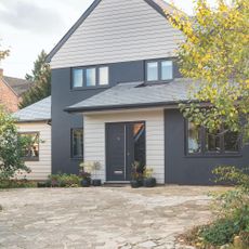 Driveway with concrete paving in front of house in the autumn