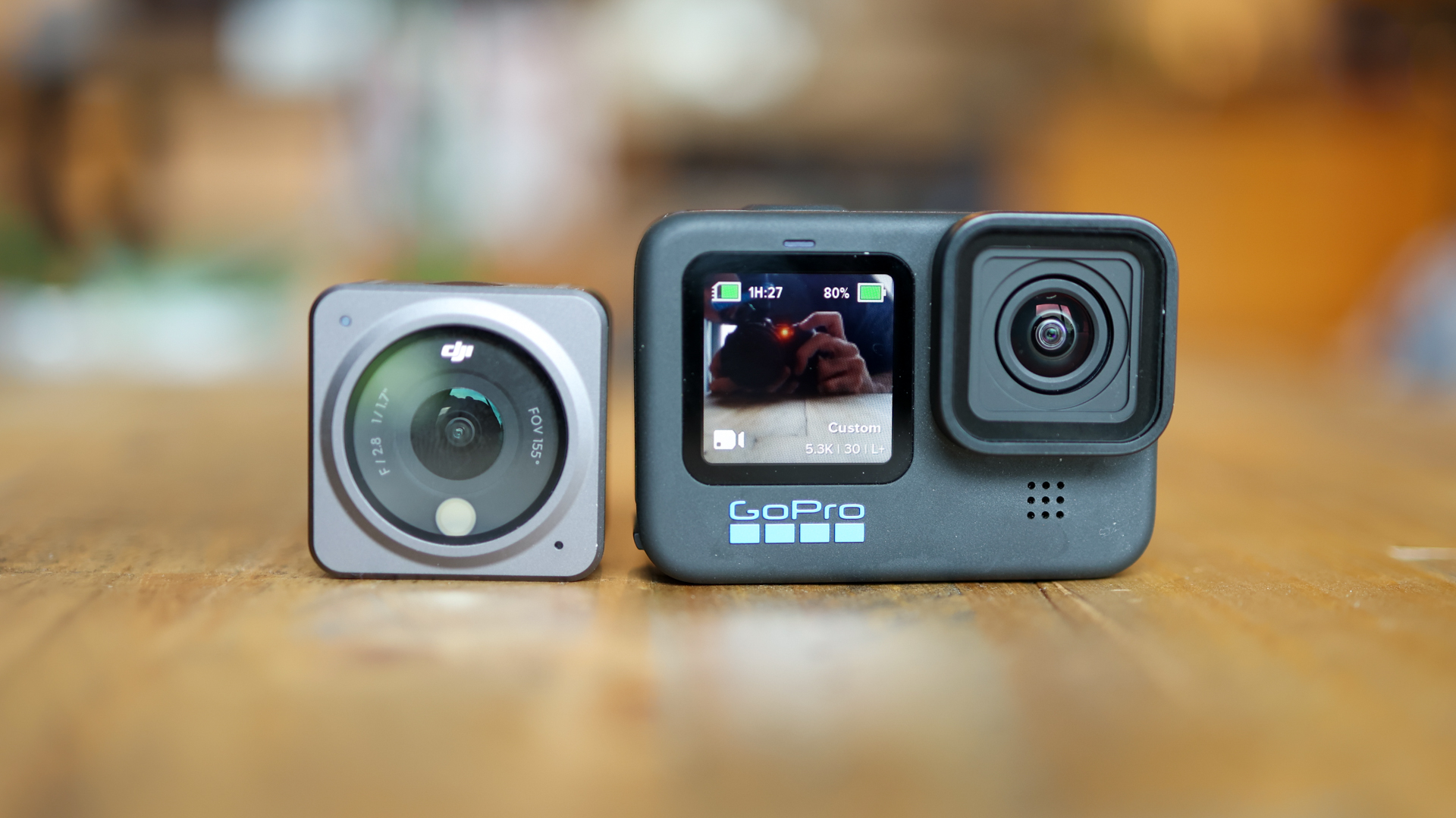 The DJI Action 2 action camera on a table next to the GoPro Hero 10 Black