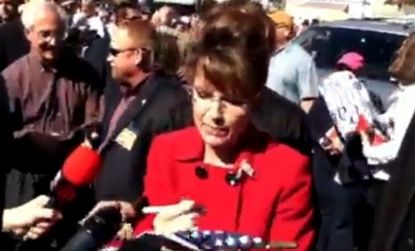 During a Tea Party rally, Sarah Palin was caught in a signing flurry, scribbling her name on books, hats and even a flag.