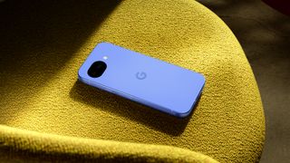 The Google Pixel 10a on a yellow surface.