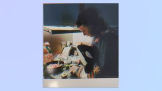 A photo of a woman cooking taken on a Kodak Mini Shot 4 Era 2-in-1 instant camera