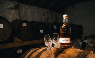 Whisky bottle and glasses on a barrel