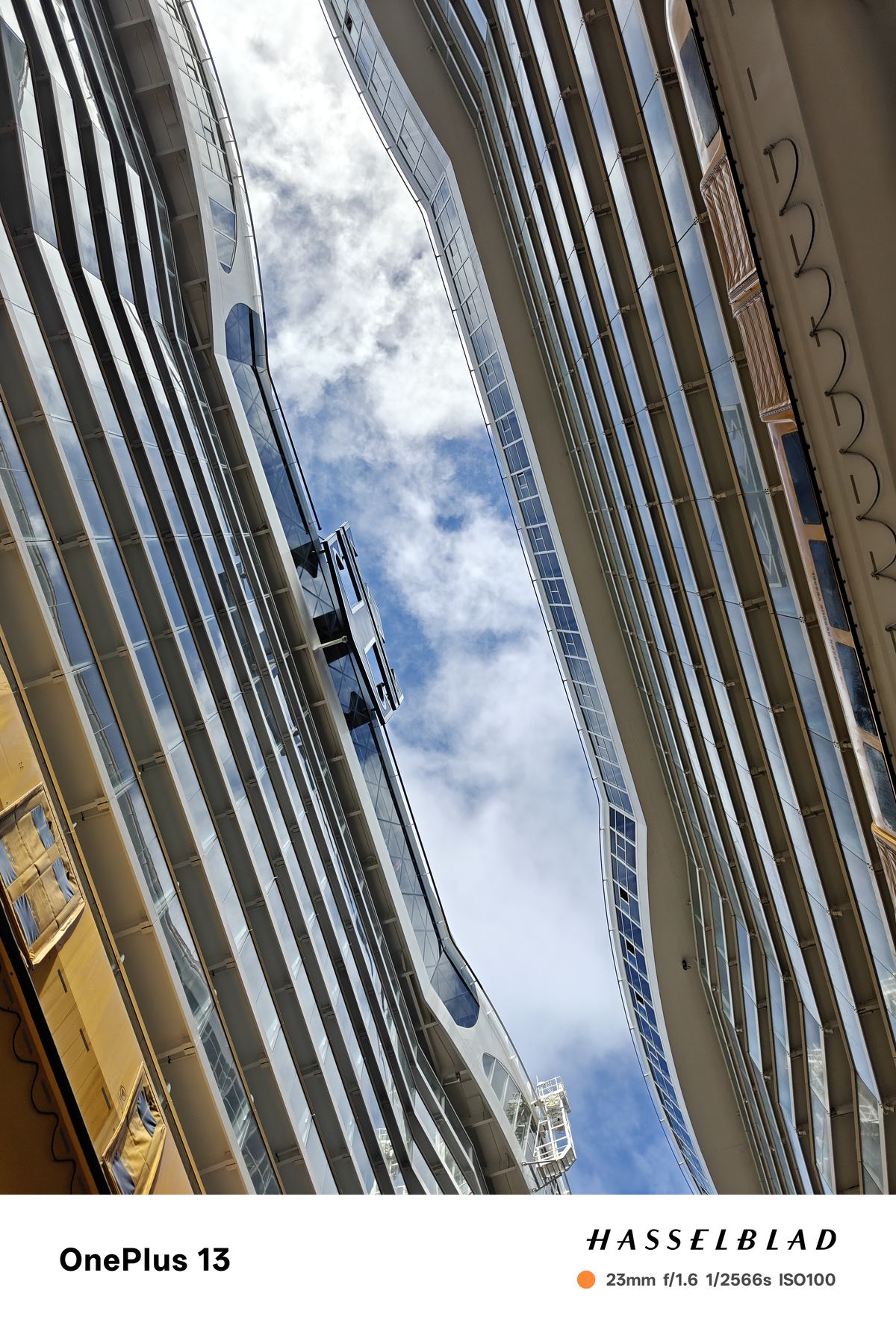 A blue and cloudy sky between two tall cruise ships