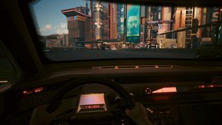 Cyberpunk 2077: driving from a first-person perspective and neon advertisements can be seen through the windshield