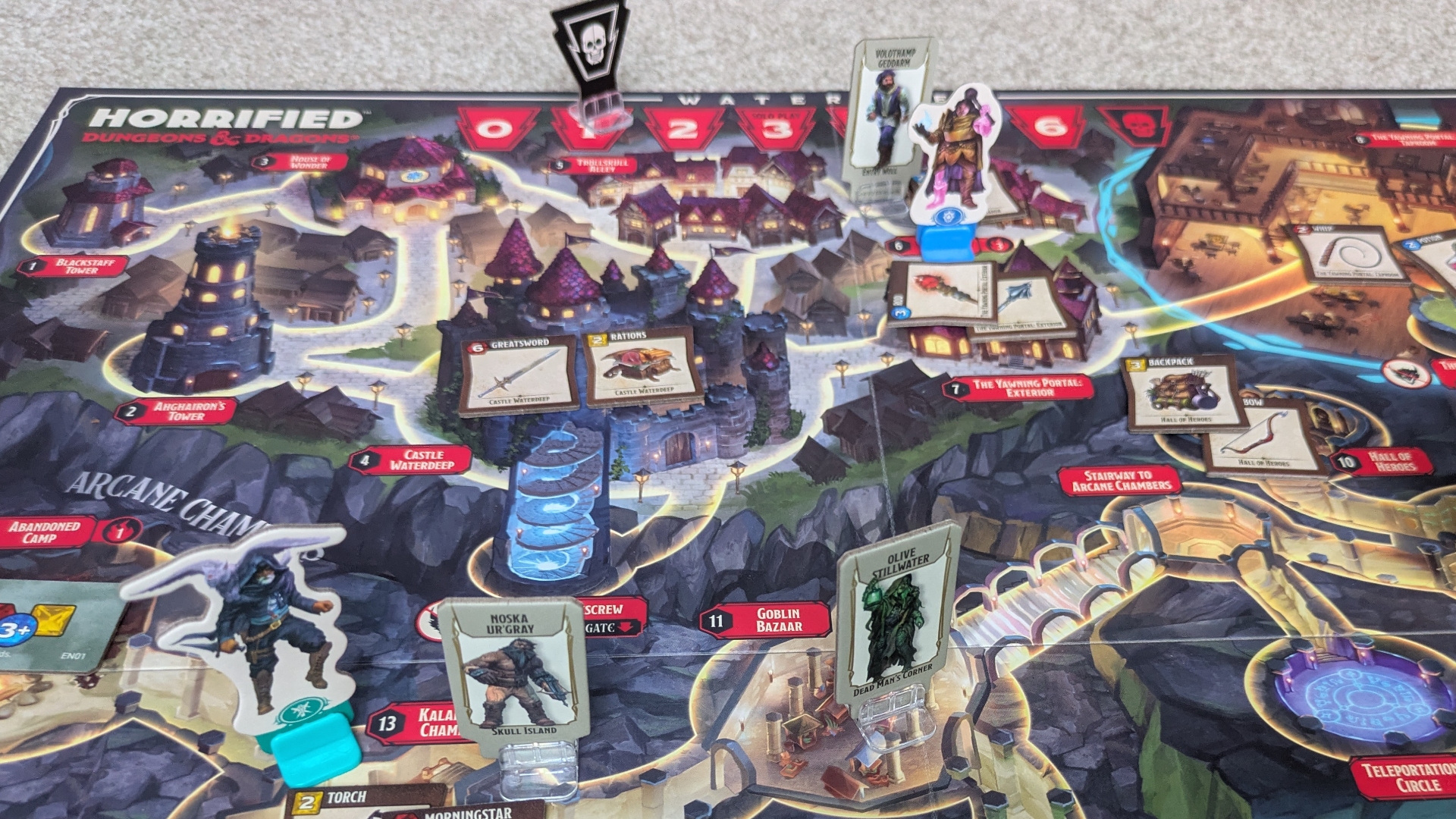 Horrified: Dungeons &amp;amp; Dragons components, tokens, and items laid out on the board, which sits on a gray surface