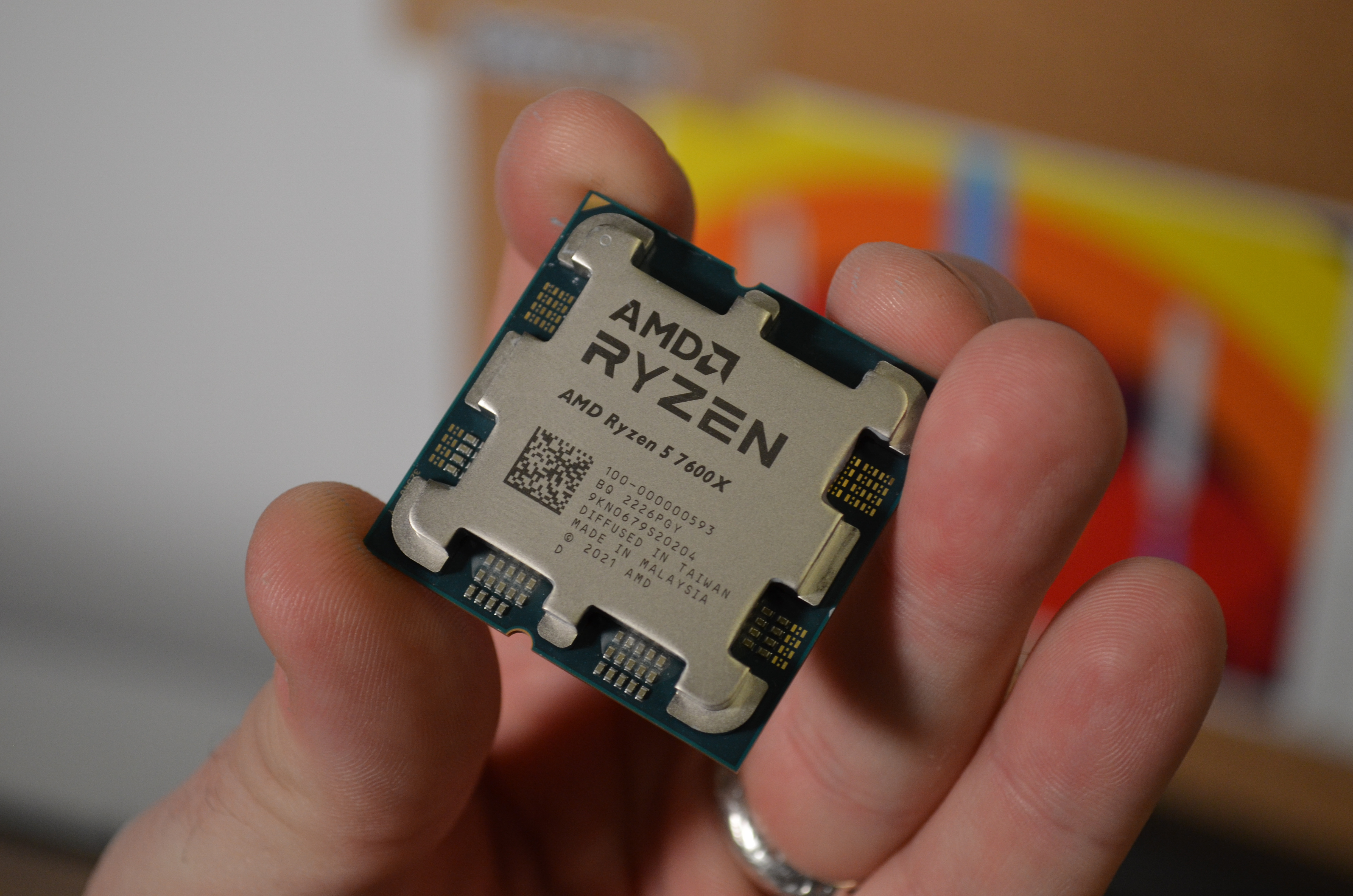 AMD Ryzen 5 7600X holdes forsiktig med fingrene
