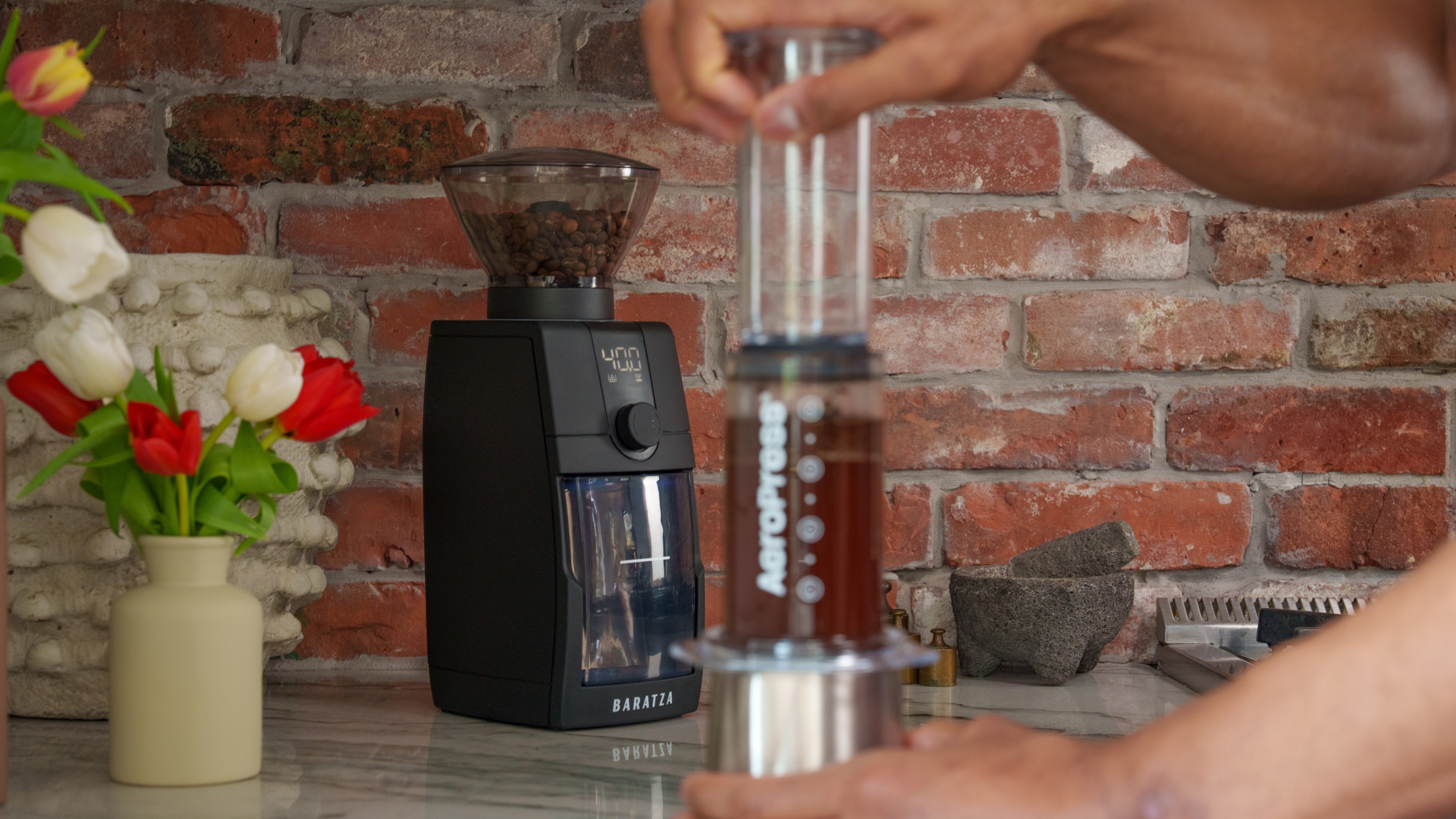 Baratza Encore ESP Pro coffee grinder with person using Aeropress coffee maker