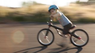 Young child moving fast on a balance bike