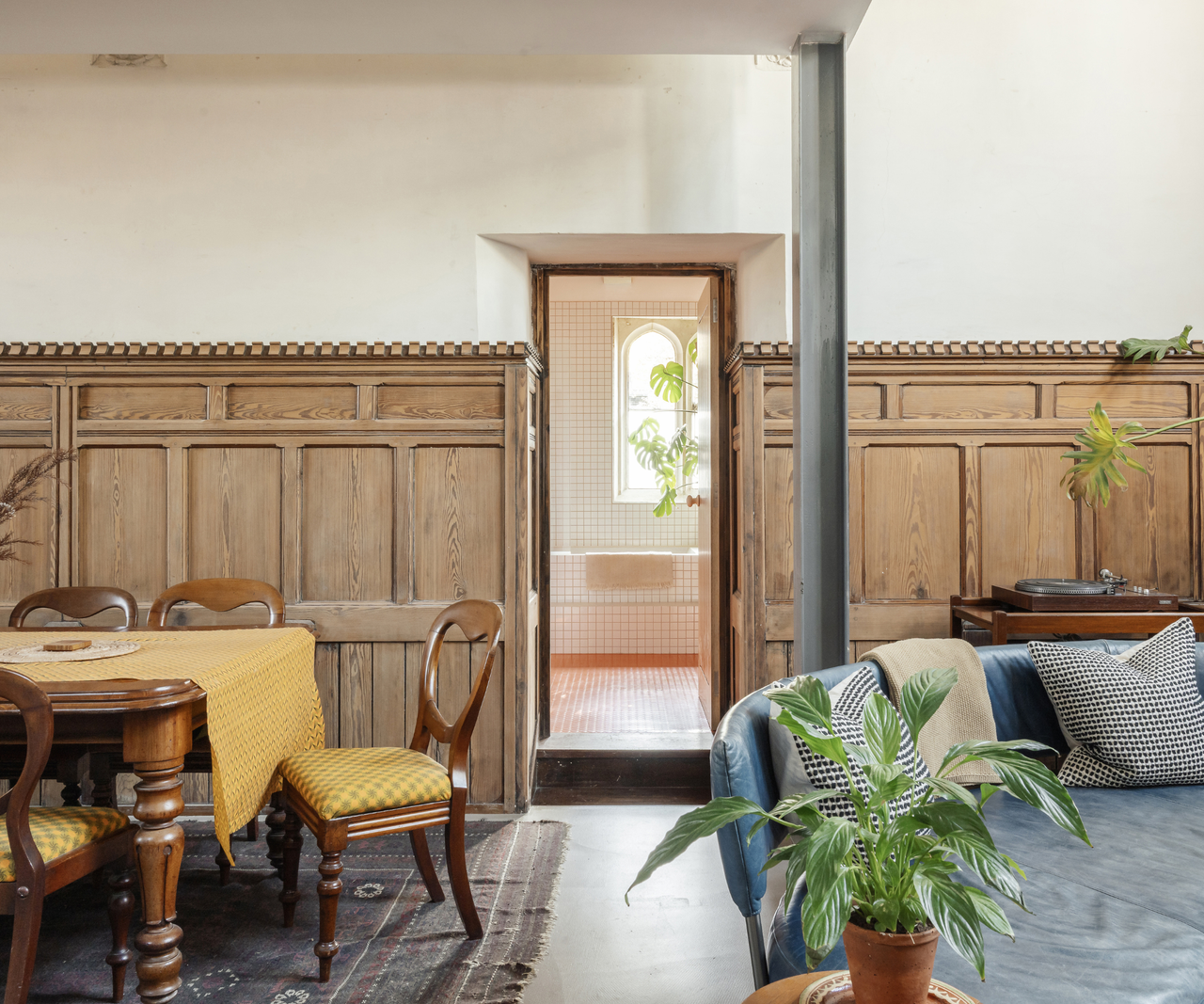 Living room with half-wall wooden panelling and a door leading onto the bathroom