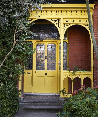 annie sloan yellow front door on victorian house with tiled steps