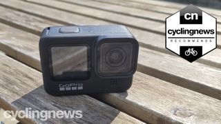 The front face of the GoPro Hero 9 Black on a wooden table overlaid with 'recommends' badge