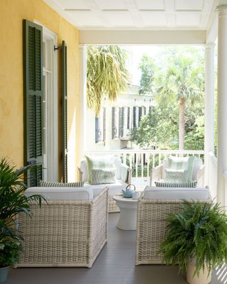 front porch on a yellow home with outdoor furniture