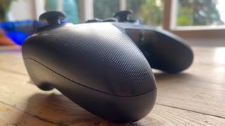 A black GameSir T4 Cyclone Pro controller sitting on a wooden desk