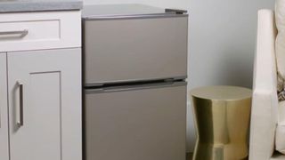 GE mini fridge next to cabinets