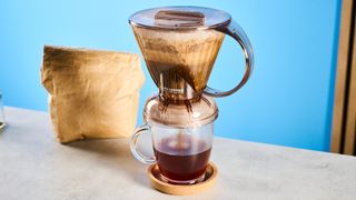 the clever dripper, a brown transparent plastic manual coffee maker with a handle and a sluice feature in the bottom to keep water inside