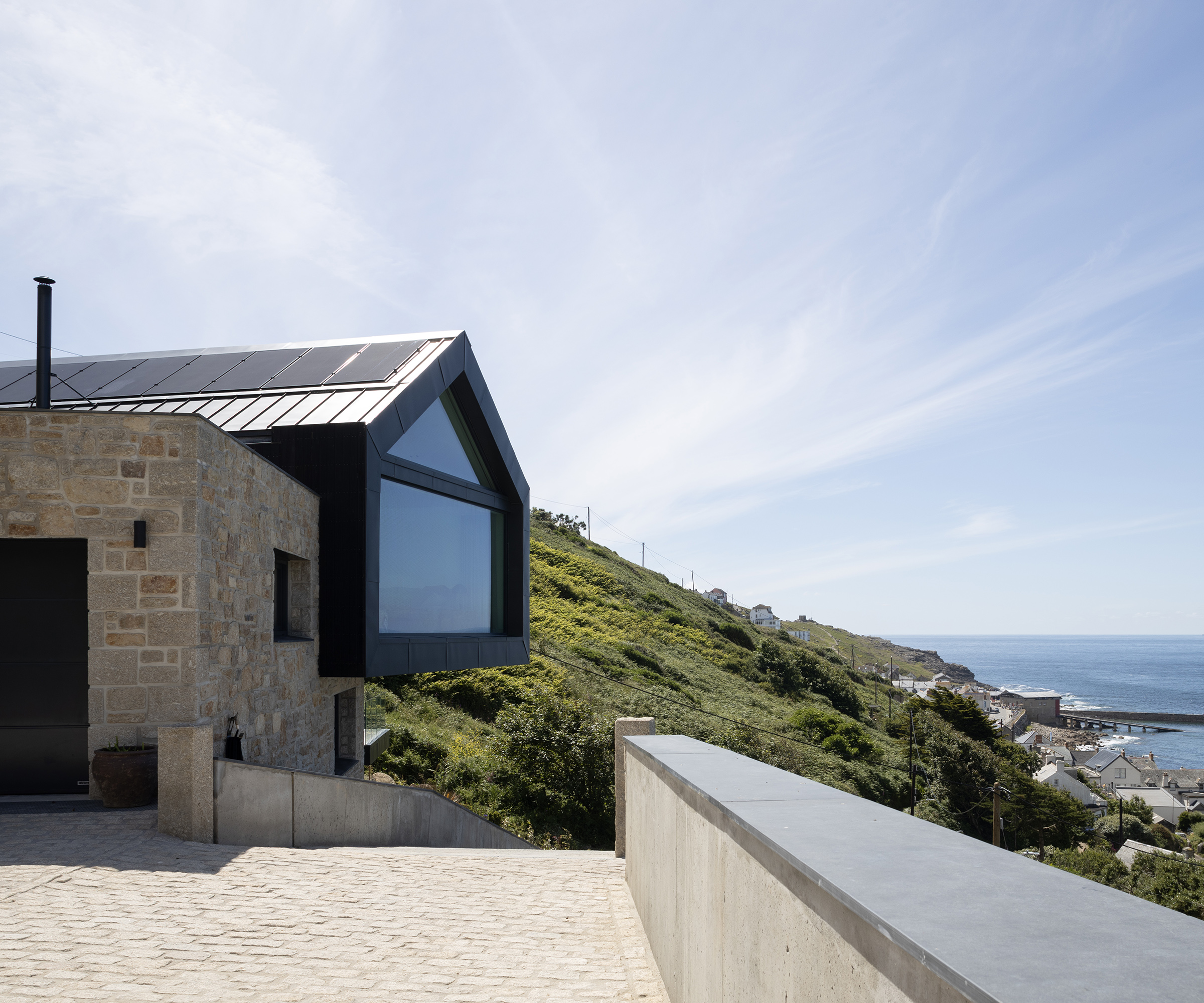 The exterior of a cantilevered new build home on a cliffside