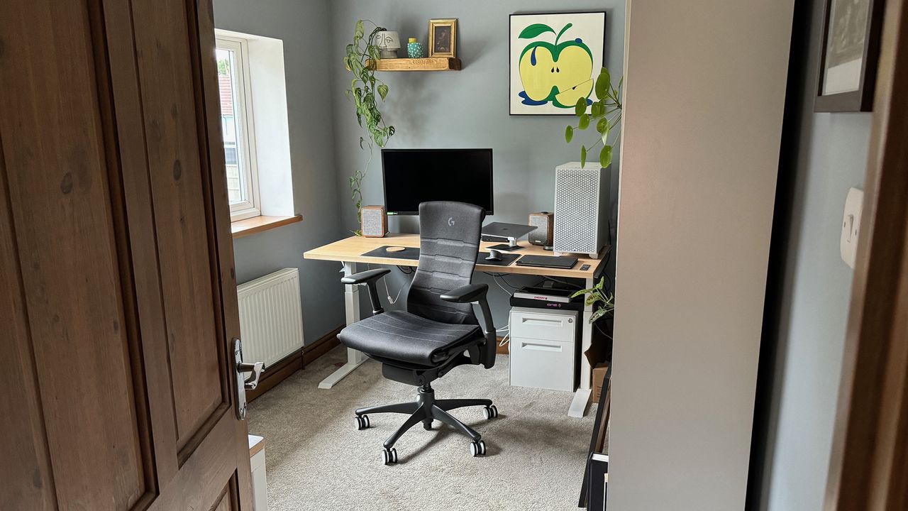 A black Embody chair next to a standing desk.