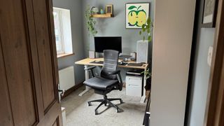 A black Embody chair next to a standing desk. 