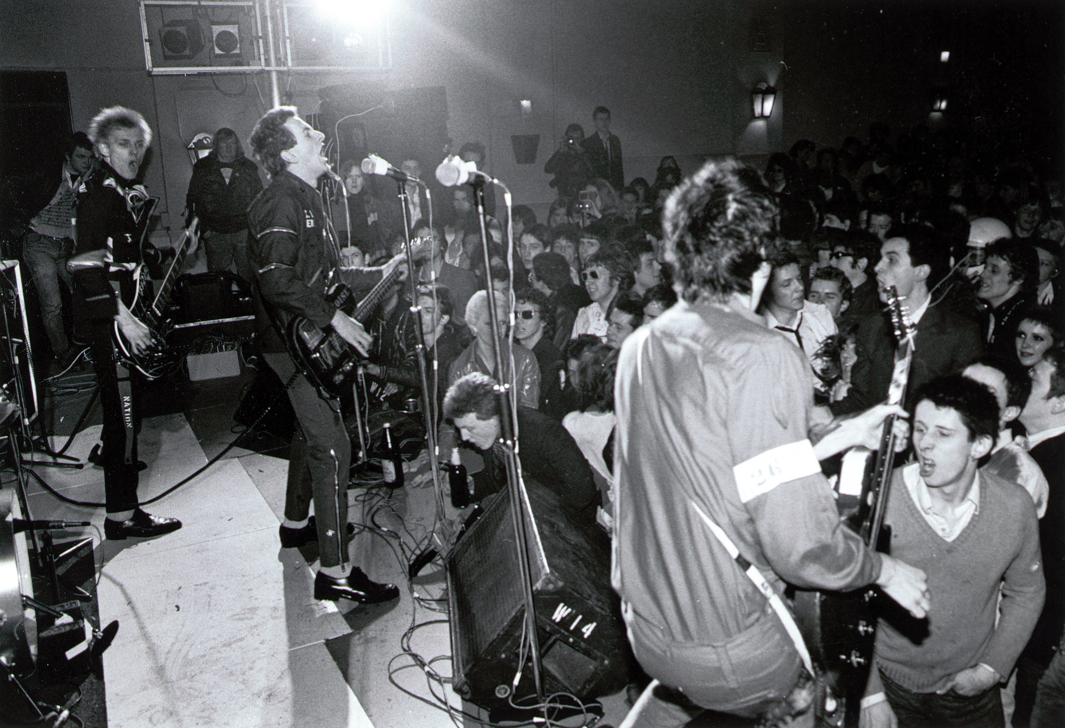UNSPECIFIED - JANUARY 01: Photo of Joe STRUMMER and Shane MacGOWAN and Paul SIMONON and Mick JONES and CLASH; Paul Simonon, Joe Strummer and Mick Jones performing live onstage, Shane MacGowan pictured in audience (Photo by Ian Dickson/Redferns)