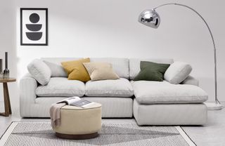 A chaise sofa with soft cushions and off-white upholstery