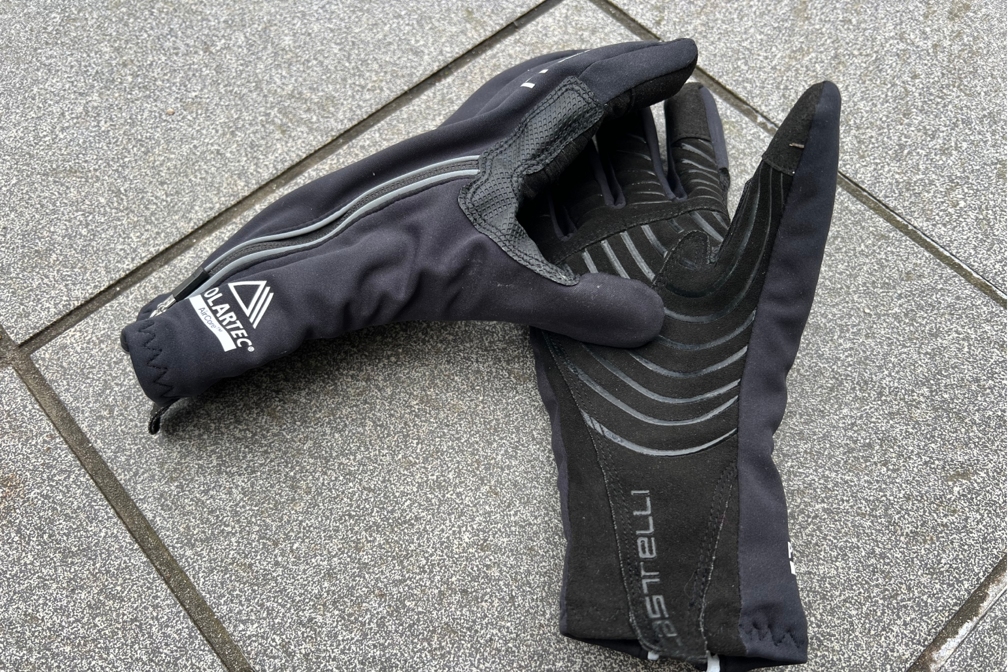 a pair of the Castelli Espresso 2 gloves on a stone tiled floor.