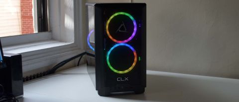 The front of a CLX Scarab gaming desktop PC on a white desk by an open window