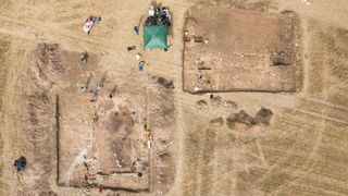 The excavation of the dining room (triclinium) on the left and an adjacent building seen from the air.