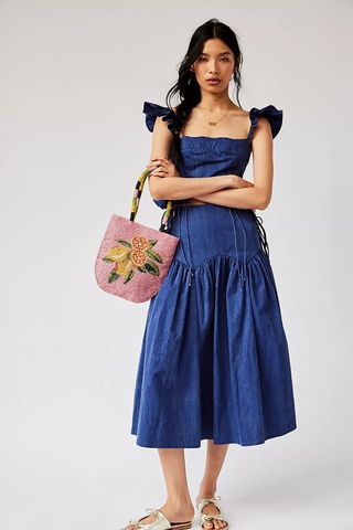 a model wears a denim dress with frilly sleeves