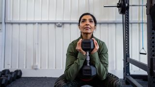 Woman doing a goblet squat with dumbbell in the gym
